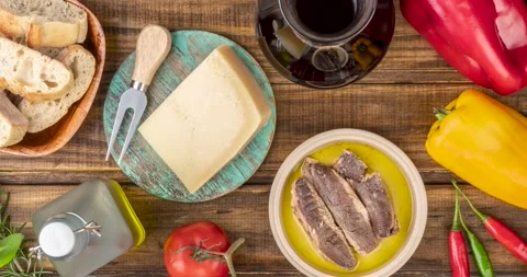 Vegetables, olive oil, bread, cheese, fish and wine and vegetables over woode Vídeo Stock 195097785