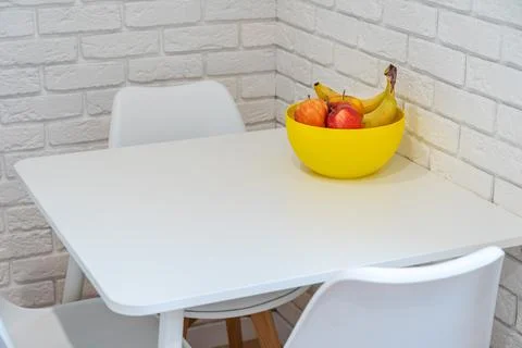 Vegetables on plate on table in kitchen with white brick wall Stock Photos