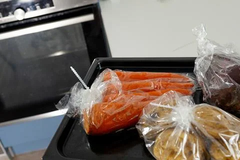 Vegetables Prepared for Baking in Sleeve Inside a Home Kitchen Stock Photos
