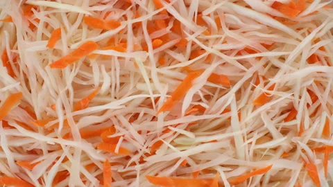 Vegetables salad with sliced white cabbage and carrot top view, rotating Stock Footage 143848672