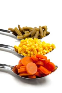Vegetables on spoons Stock Photos