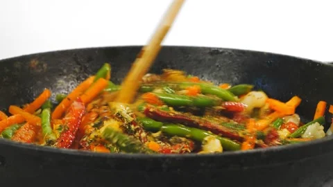Vegetables in a stewed pan are mixed with a wooden spatula 库存影片 199822016