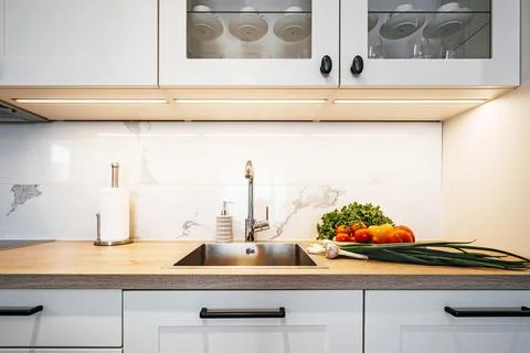 Vegetables on the table in the kitchen tap and sink Stock Photos