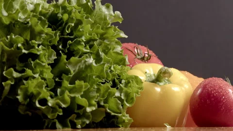 Vegetables tomatoes and peppers of different colors with lettuce leaves Video stock 267629423