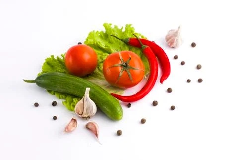 Vegetables on a white background. Cucumbers with tomatoes and garlic on a whi Stock Photos
