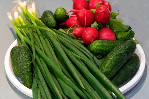 Vegetables on a white plate on the kitchen table. Stock Photos