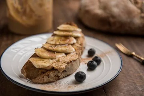 Vegetarian breakfast with toasted rustic bread with peanut butter and banana Stock Photos
