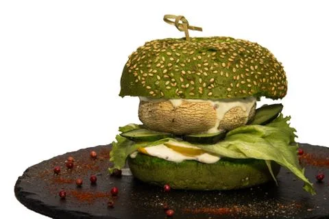 Vegetarian burger with a leaf of green salad, champignon, cucumbers and sauce. Stock Photos