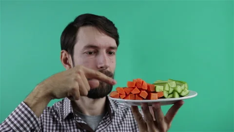 Vegetarian man holding cucumber and carrot slices show thumb up Stock Footage 124682653