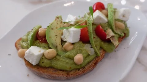 Vegetarian mashed avocado toest with tomatoes and mozzarella cheese. Video stock 301368196