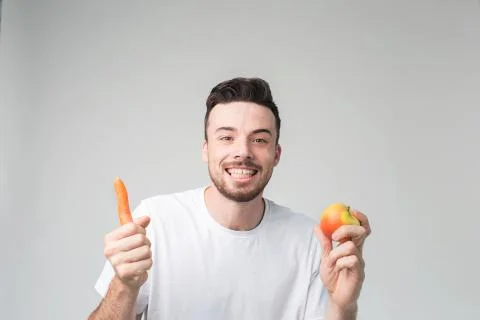 Vegetarian preparing a meal. Smiling guy loves fruits and vegetables Foto stock