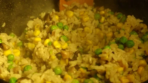 Vegetarian risotto is cooked in a pan and stirred with a wooden spatula Stock Footage 230217709