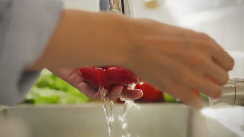 Vegetarian using tap with water concentratedly washes vegetables under water Stock Footage 282656755