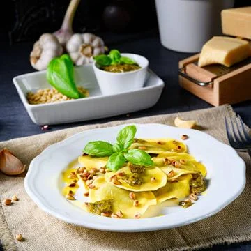 Vegetariano italiano! Tortelli with roasted pine nuts and pesto basilico V... Stock Photos