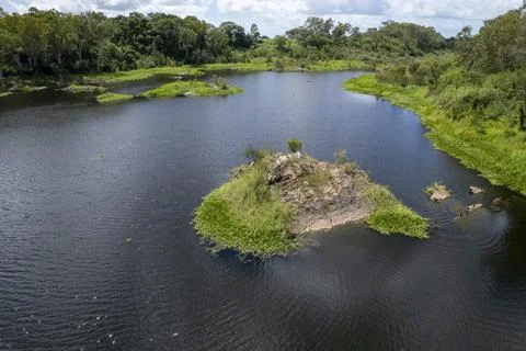 Vegetation Covered Rocks In A River Downstream From A Dam Stock Photos