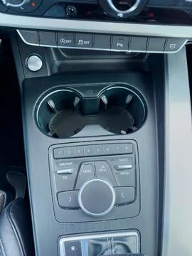 Vehicle console showcasing various controls and cup holders in a modern car.. Stockfoto's