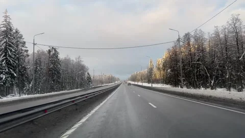 Vehicle navigating icy road in snowfall under cloudy sky Vídeo Stock 268398830