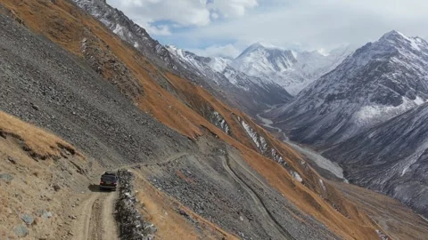 Vehicle navigating rugged mountain terrain with dramatic landscape views Stock Footage 319517073