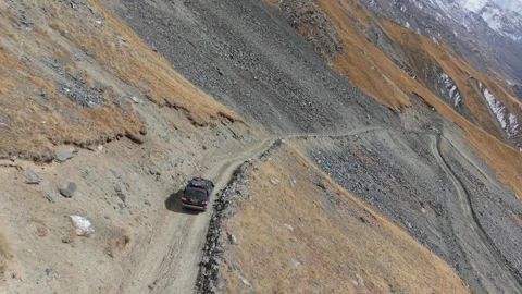 Vehicle navigating rugged terrain with dynamic aerial camera movement Stock-Footage 319560548