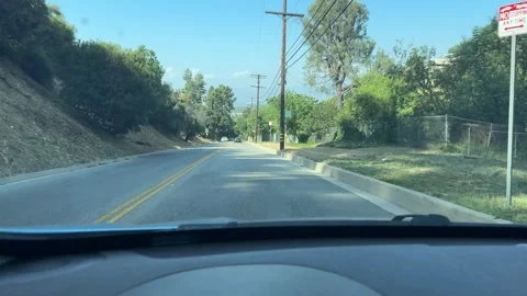 Vehicle perspective driving on two-lane asphalt road under clear sky, view of Stock Footage 339864390