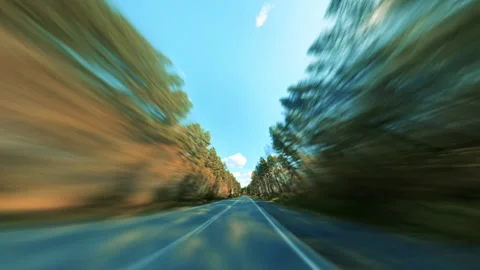 A Vehicle Swiftly Navigating a County Road Through a Picturesque Autumn Forest. Stock Footage 295246030