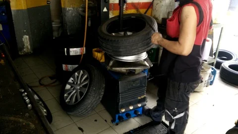 Vehicle technicians are in the process of replacing the new tires Stock Footage 86964449