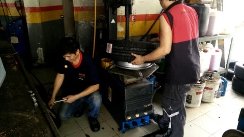 Vehicle technicians are in the process of replacing the new tires Stock Footage 86964514