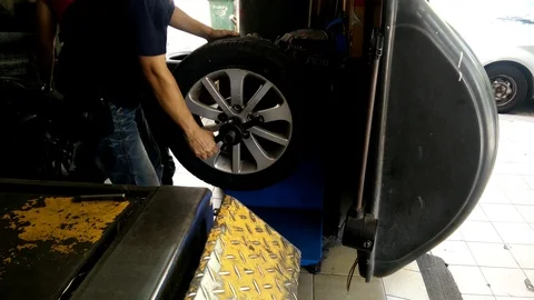 Vehicle technicians are in the process of replacing the new tires Stock Footage 86964545