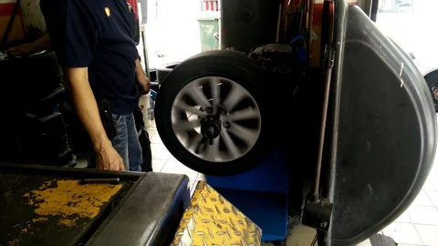 Vehicle technicians are in the process of replacing the new tires Stock Footage 86964606