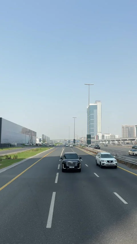 Vehicle traffic flows through Dubai's streets with cars changing lanes contin Stock Footage 313388685