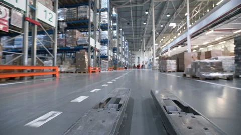 Vehicle trucks move at large rows between shelf with cardboard boxes, products, Stock Footage 199490287