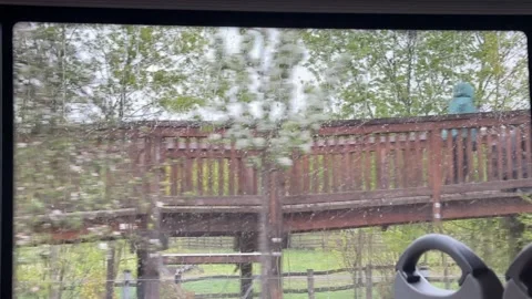 Vehicle window view capturing rainfall droplet movement on glass surface, Stock Footage 333163810