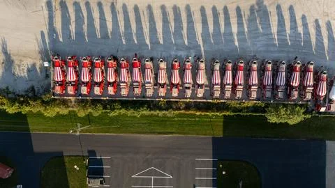 The vehicles are parked in a row, casting long shadows Foto stock