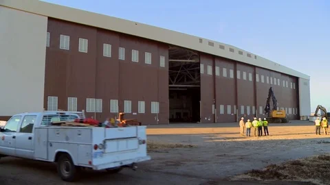 Vehicles arrive to hangar under construction Stock Footage 109355414