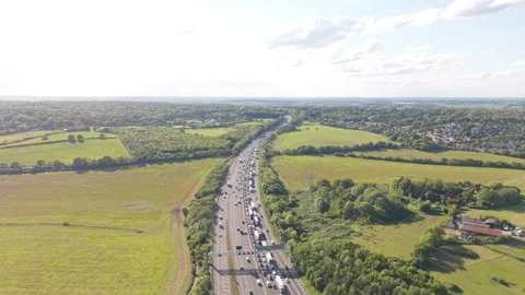 Vehicles Crawl on Busy Multi-Lane Highway in Lush Green Countryside Stock Footage 335292343