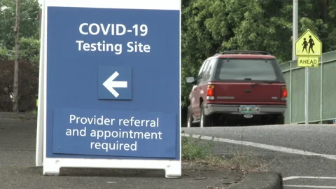 Vehicles Drive By COVID 19 Test Site Sign Stock Footage 133013482