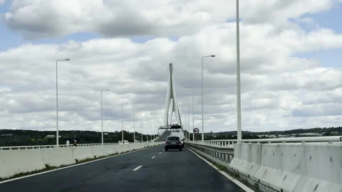Vehicles drive toward the modern cable stayed bridge crossing the Guadiana River Stock Footage 330745167