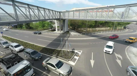 Vehicles Driven Through Traffic Circle Under Pedestrian Bridge Stock Footage 62272681