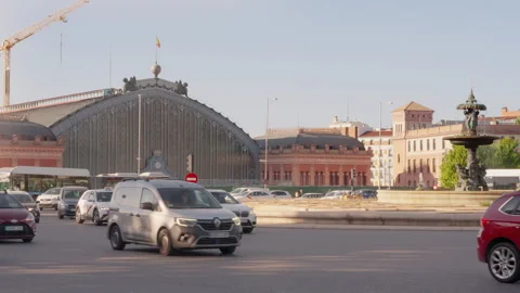 Vehicles driving through a roundabout in front of the Atocha train station Stock Footage 334044941
