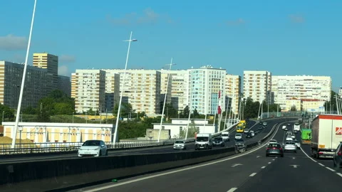 Vehicles entering Lisbon on elevated highway with residential backdrop Stock Footage 320710520
