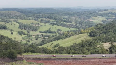 Vehicles on a highway with beautiful green fields and woods. BR 282. Video stock 331332598