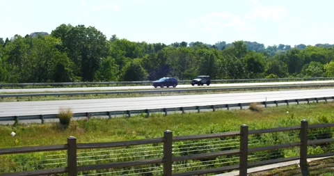 Vehicles on highway side view speeding along on a summer day Stock Footage 205535361