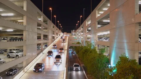 Vehicles leaving a parking structure at night in traffic. Stock Footage 99058709