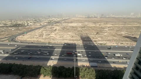 Vehicles move through Al Khail Road in Dubai, as the city skyline rises in the Vídeo Stock 331414622