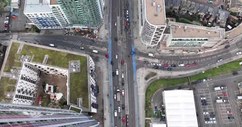 Vehicles moving on Track  surrounded by High rise tower and  residential houses 스톡 동영상 170944037