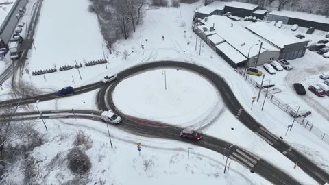 Vehicles navigating a snowy roundabout in winter. Cars riding Video stock 328647272