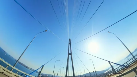 Vehicles Navigating a Stunning Cable-Stayed Bridge Under a Clear Blue Sky. Cars Stock Footage 329610771