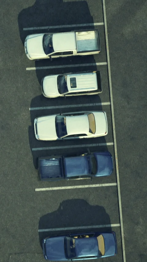 Vehicles parked in organized rows at a parking lot during daytime hours Stock-Footage 331686245