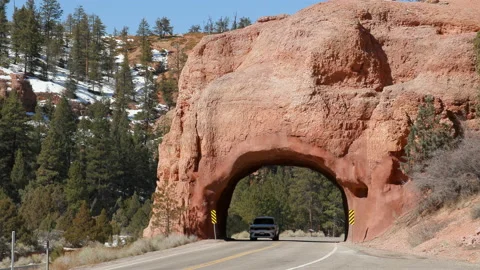 Vehicles pass under a natural arch tunnel on Highway 12, Utah. Stock Footage 151125990
