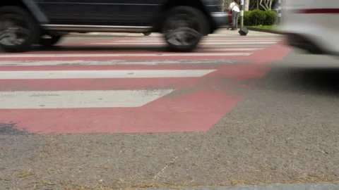 Vehicles passing on a crosswalk while pedestrians are using it Vidéo 307233980